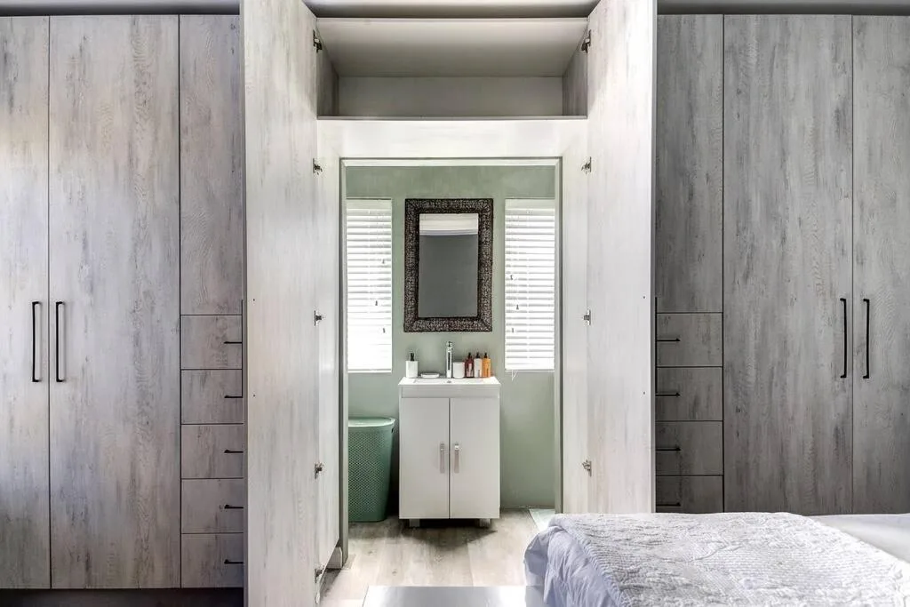 Modern bathroom with white vanity, mirror, and sage green walls