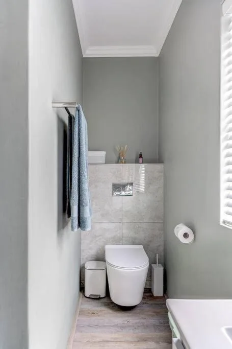 Modern bathroom with toilet, vanity cabinet, and towel rail