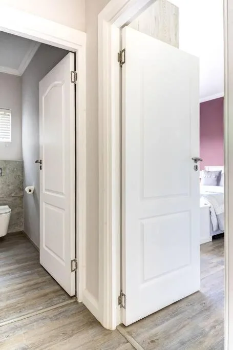 Modern bathroom with white panel doors and wood-look flooring