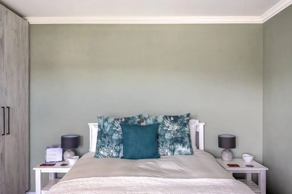 Spacious bedroom with queen bed, decorative pillows, and bedside tables