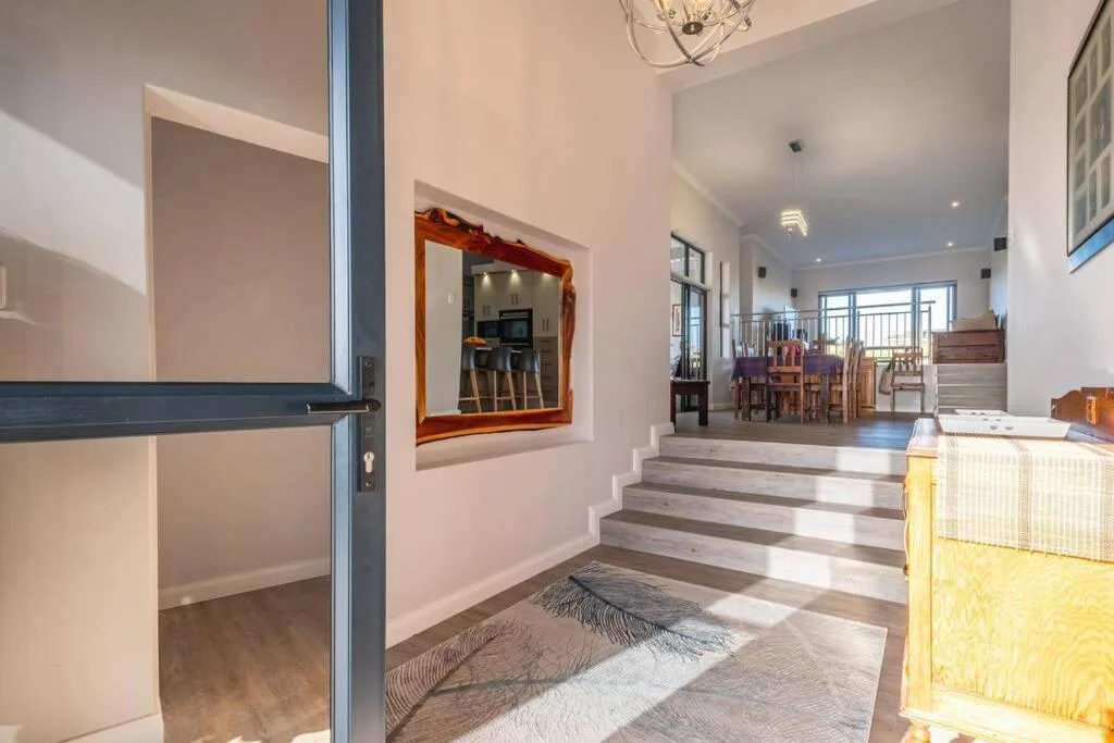 Bright interior entrance hall with wooden steps and modern decor