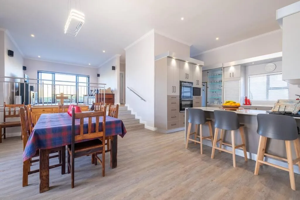 Open-plan dining and kitchen area with wooden table and modern cabinetry