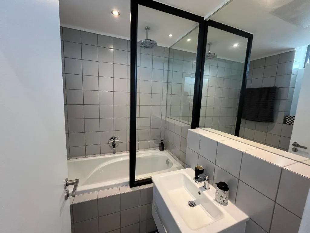 Modern bathroom with bathtub, double vanity sink, and large mirror