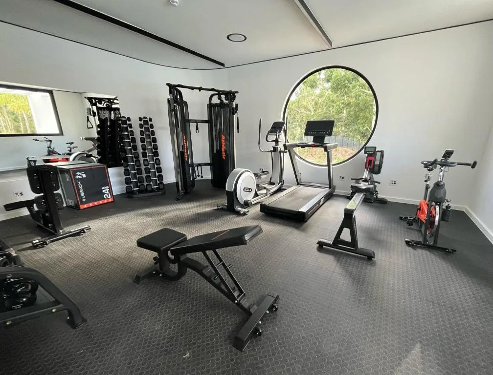 Modern gym facility with treadmill, stationary bike, weights, and exercise equipment