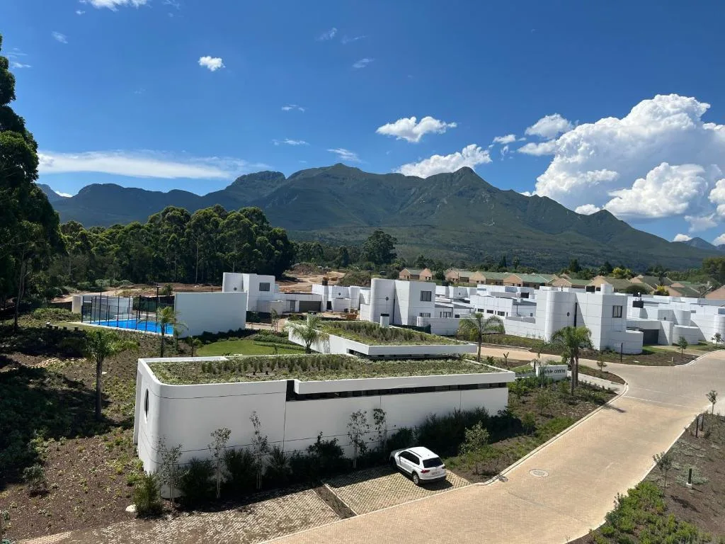 Modern white apartments with mountain views and green surroundings