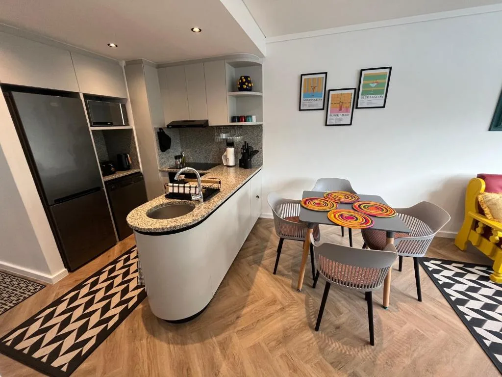 Modern kitchen with granite counters, black appliances, and adjoining dining area