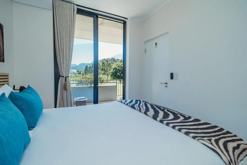 Bright bedroom with mountain view through large glass doors and balcony