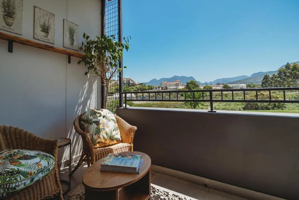 Balcony with wicker seating overlooking mountains and valley landscape