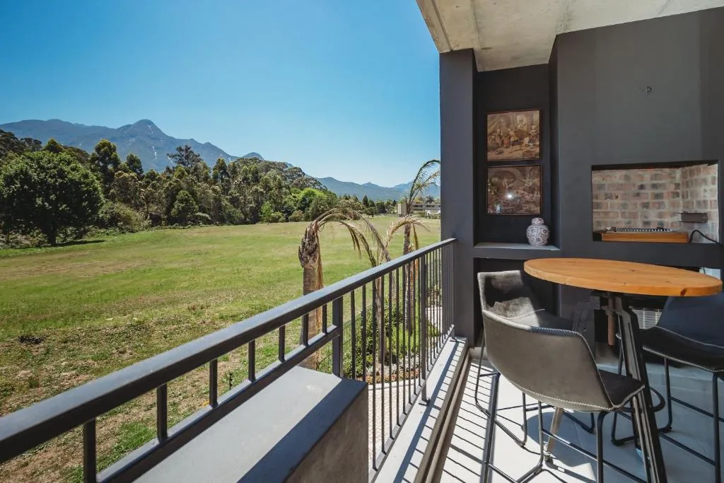 Balcony with mountain views, wooden table, and green landscape beyond