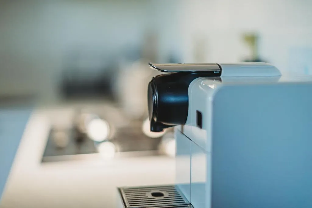 Close-up of modern coffee machine with chrome spout and drip tray