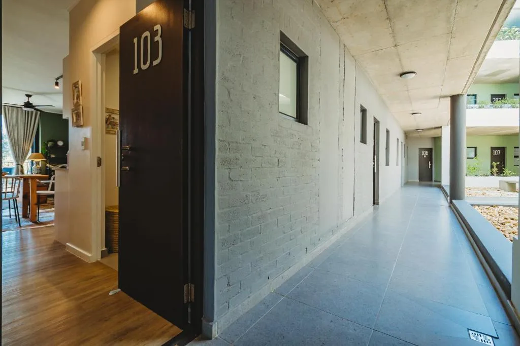 Modern apartment building entrance with numbered unit doors and covered walkway