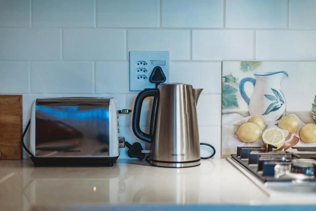 Kitchen counter with electric kettle, toaster, and decorative ceramic pitcher