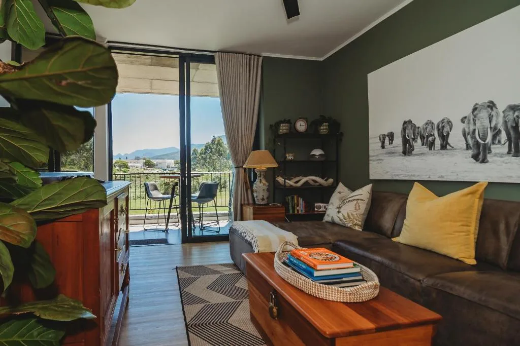 Modern lounge with leather sofa, mountain views through glass doors, African decor and artwork