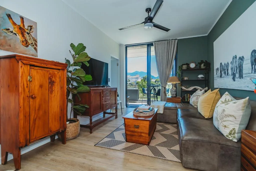 Modern lounge with sofa, wooden furniture, mountain views through glass doors