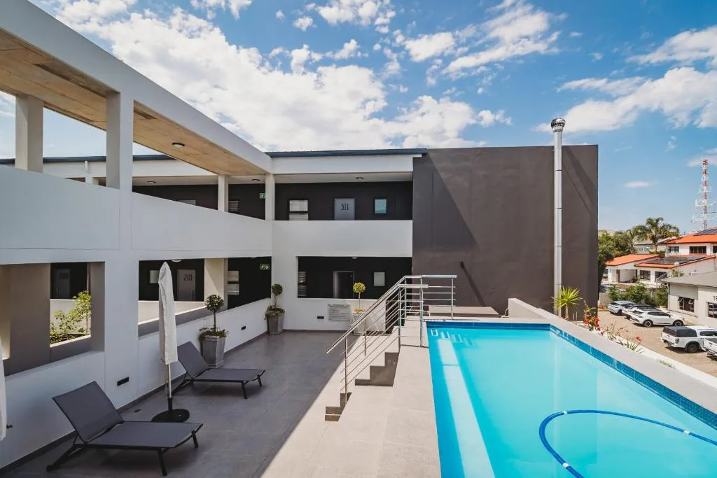 Modern swimming pool with loungers on contemporary deck area
