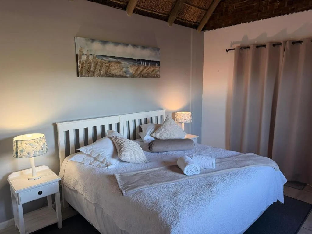 Bright bedroom with white wooden bed frame and soft linens perfectly arranged