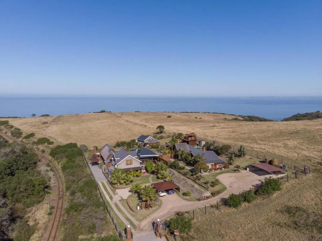 Aerial view of country villa complex with ocean horizon backdrop