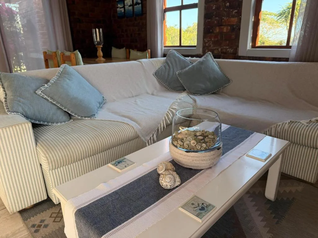 Cream sofa with blue cushions and coastal decor in bright living room