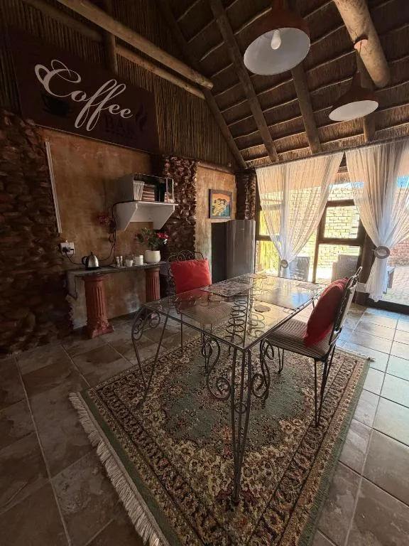 Rustic lounge area with dining table, coffee station, and red accent chairs