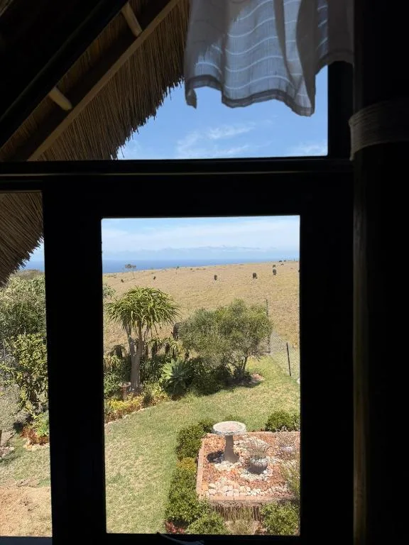 Scenic landscape view through window framing rolling hills and ocean horizon