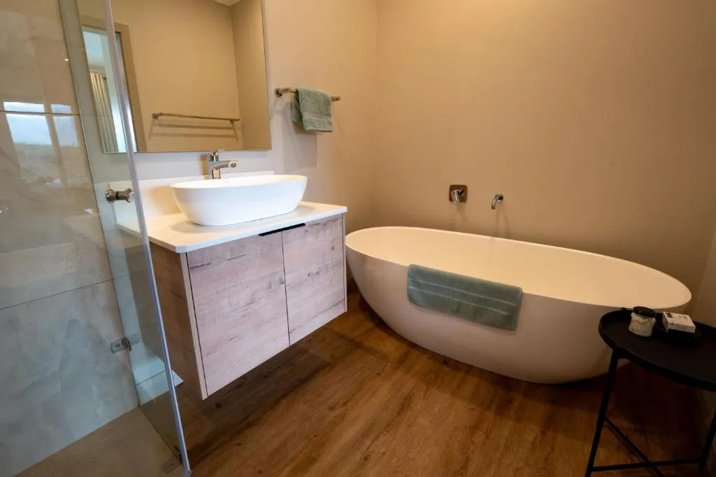 Modern bathroom with freestanding bathtub, vessel sink, and glass shower enclosure