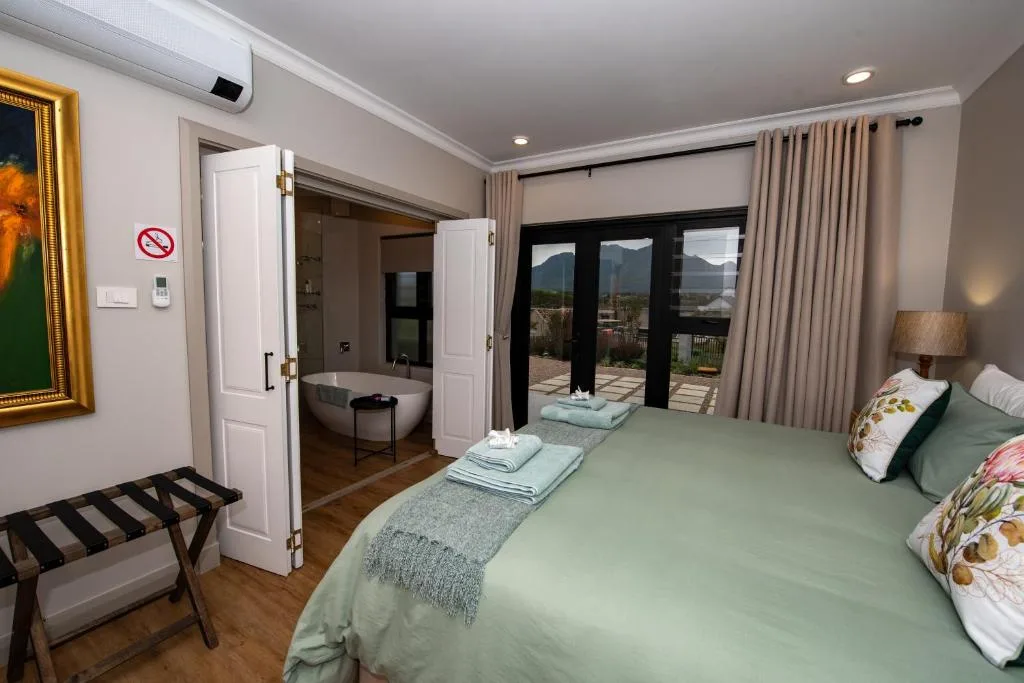 Spacious bedroom with queen bed, mountain views through sliding doors, ensuite bathroom access
