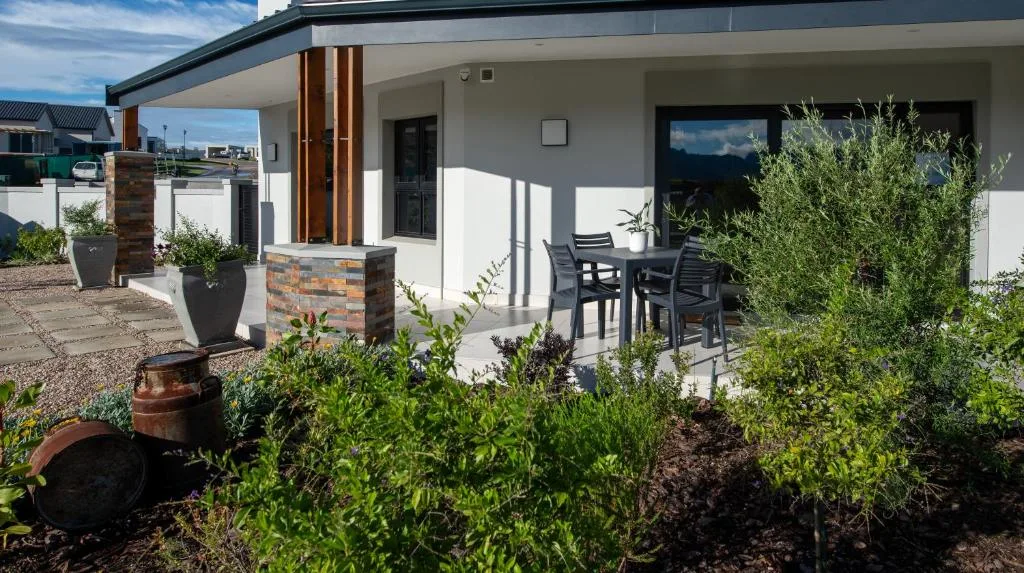 Modern patio with outdoor dining table and landscaped garden beds