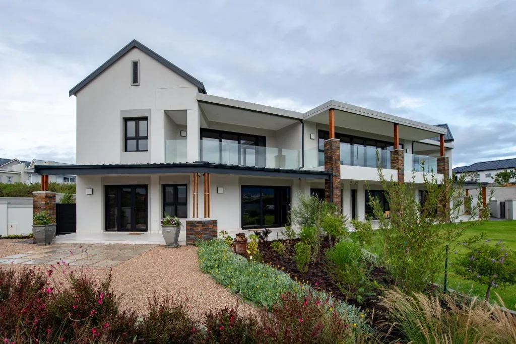 Modern two-story white house with brick accents and large windows