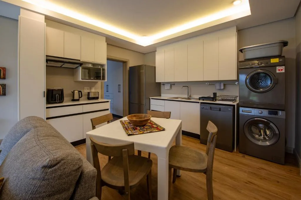 Modern kitchen with white cabinetry, stainless steel appliances, dining table