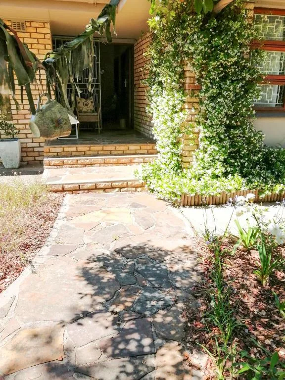 Brick entrance with ivy-covered walls and flagstone pathway