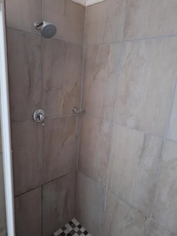 Tiled shower cubicle with rainfall showerhead and wall controls