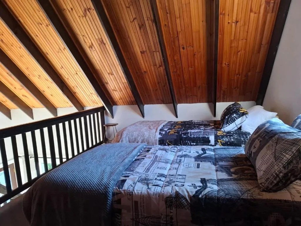 Spacious bedroom with wooden beamed ceiling and contemporary furnishings