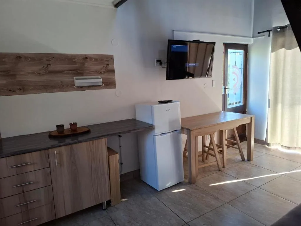 Modern kitchen with wooden cabinetry, white refrigerator, and dining table