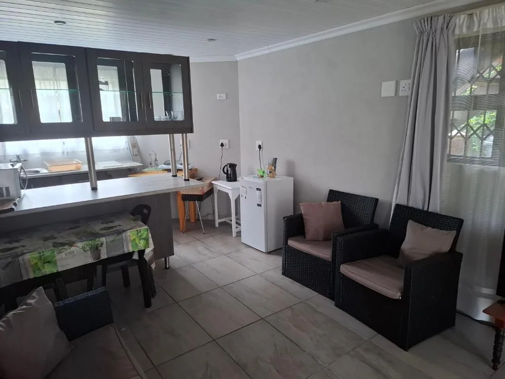 Spacious lounge with black wicker armchairs and work desk area