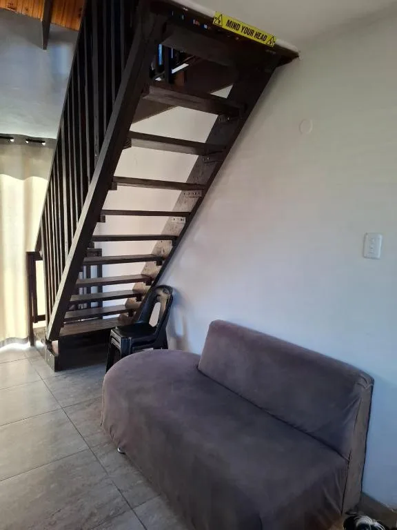 Modern lounge area with grey sofa and dark staircase