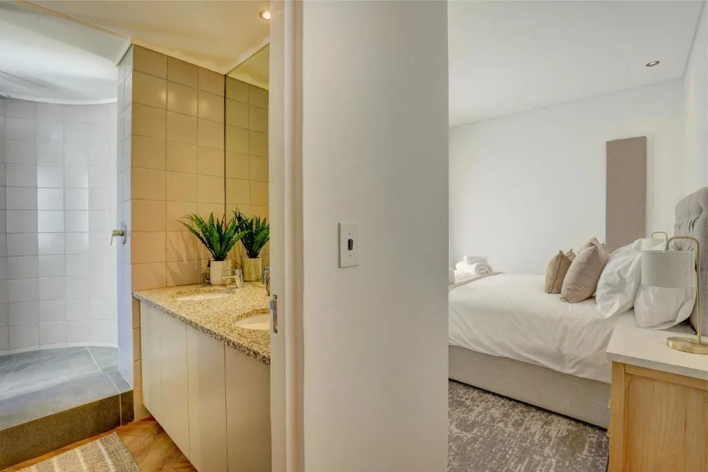 Bright bedroom with ensuite bathroom featuring granite counters and yellow tile