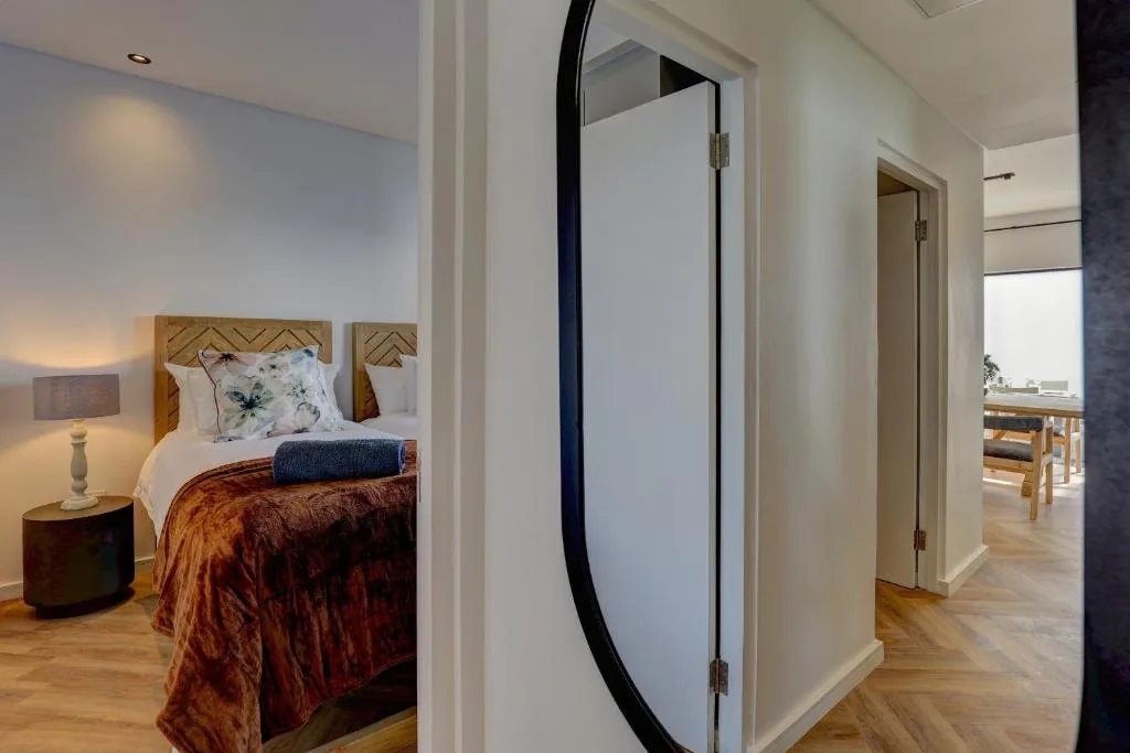 Bedroom with geometric headboard, warm lighting, and en-suite bathroom door