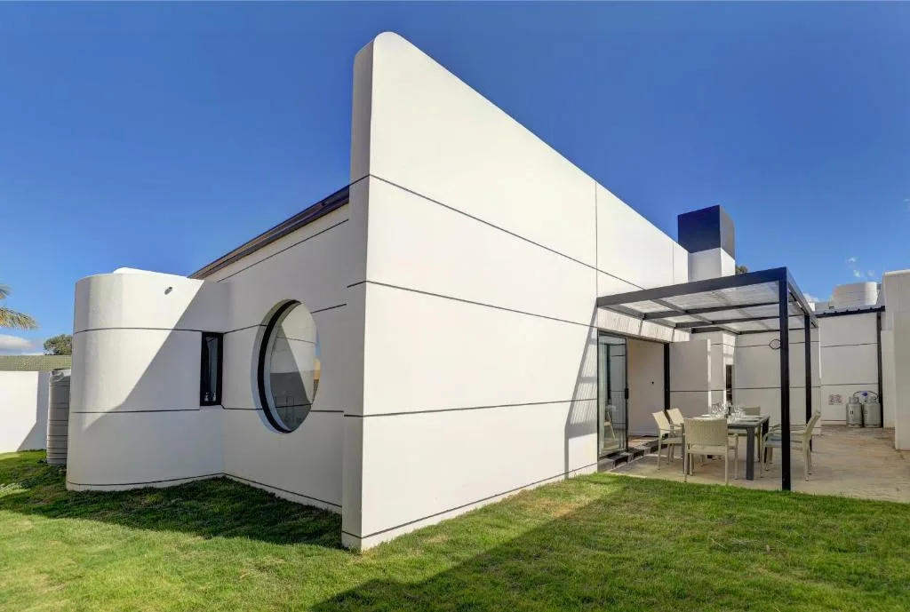 Modern white holiday home with covered deck and outdoor seating area