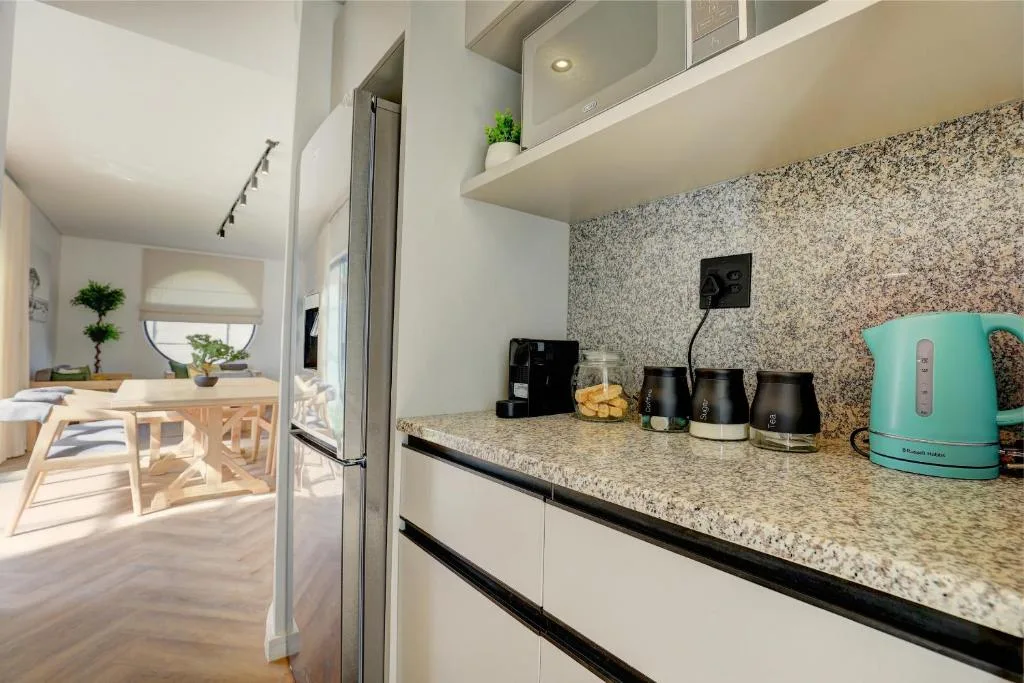 Modern kitchen with granite countertop, stainless steel appliances, and turquoise kettle
