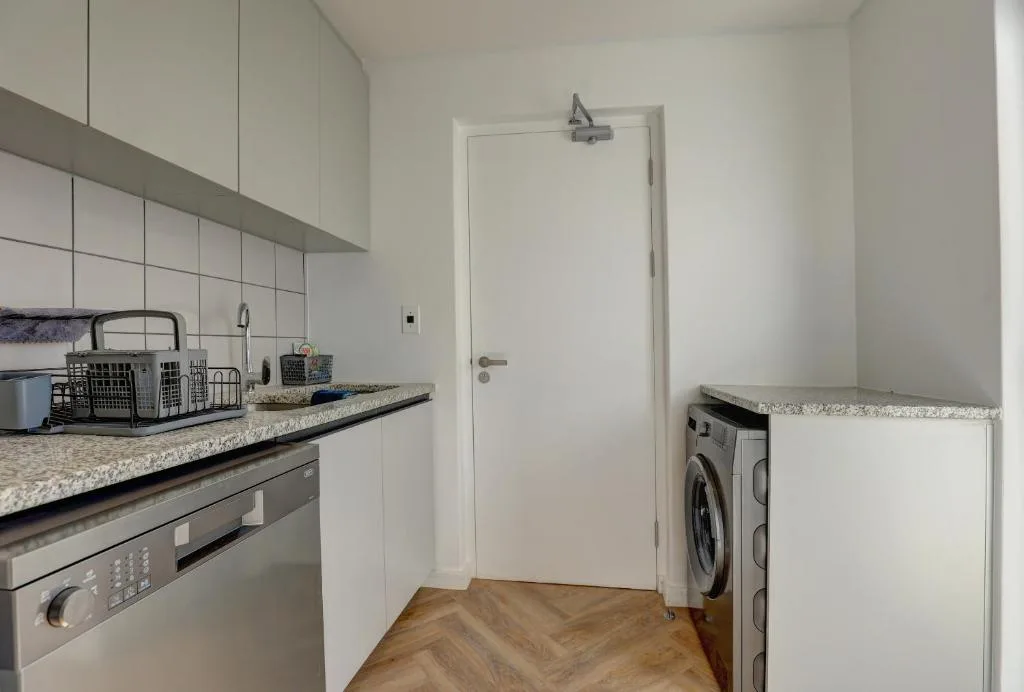 Modern kitchen with stainless steel appliances, granite countertops, and washing machine