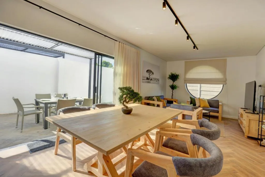 Open-plan lounge and dining area with wooden furniture and natural light