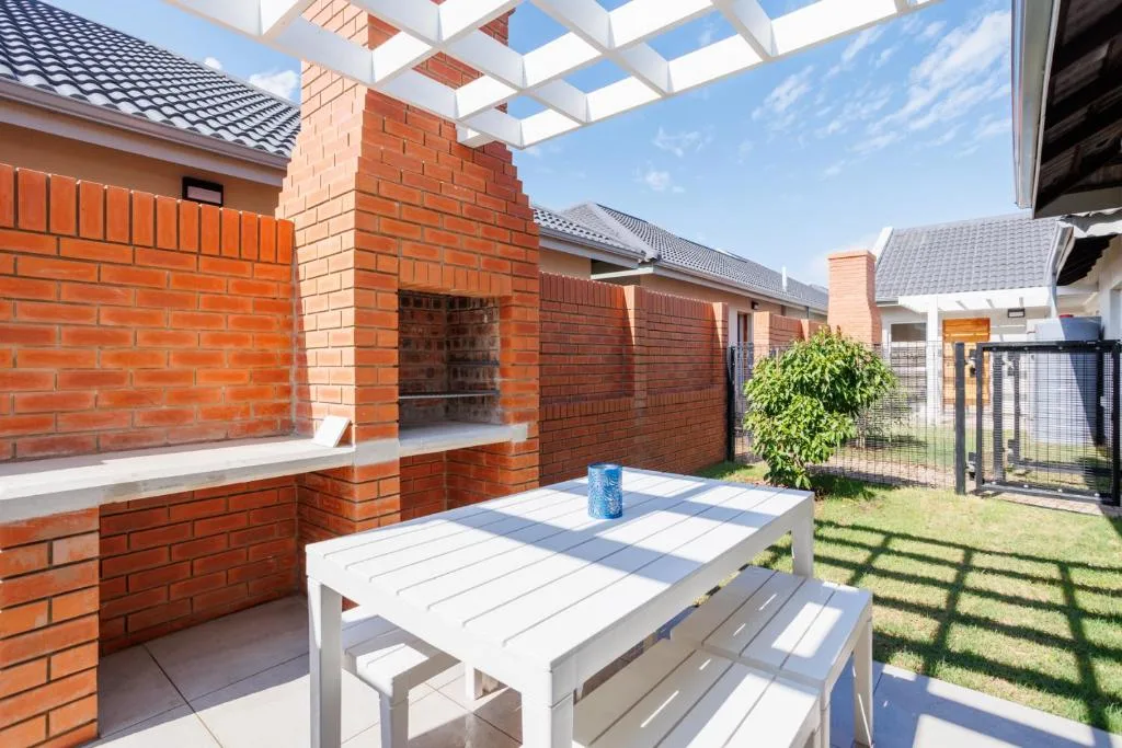 Outdoor patio with dining table and brick braai area