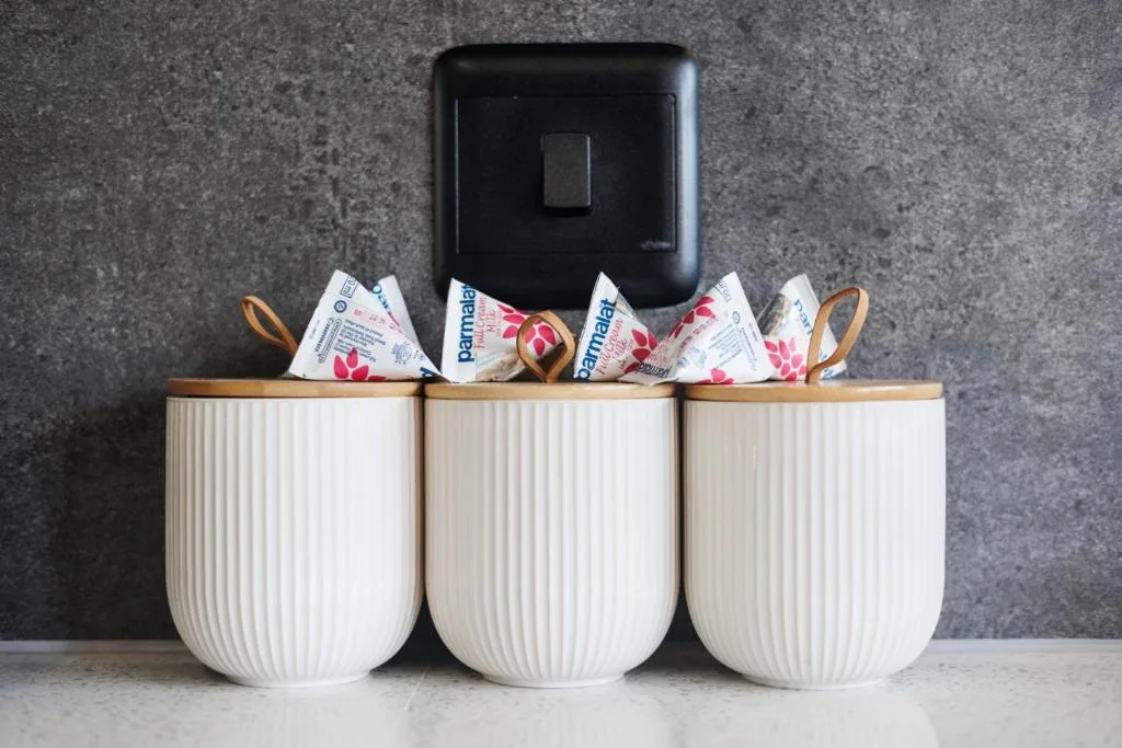 White ribbed storage containers with toiletries and light switch above