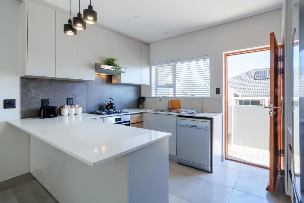 Modern kitchen with white cabinetry, island counter, and stainless steel appliances