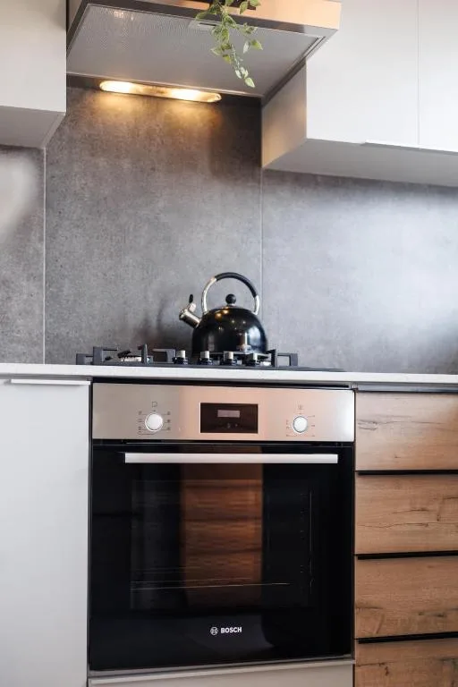 Modern kitchen with black Bosch oven, gas cooktop, and gray tile backsplash
