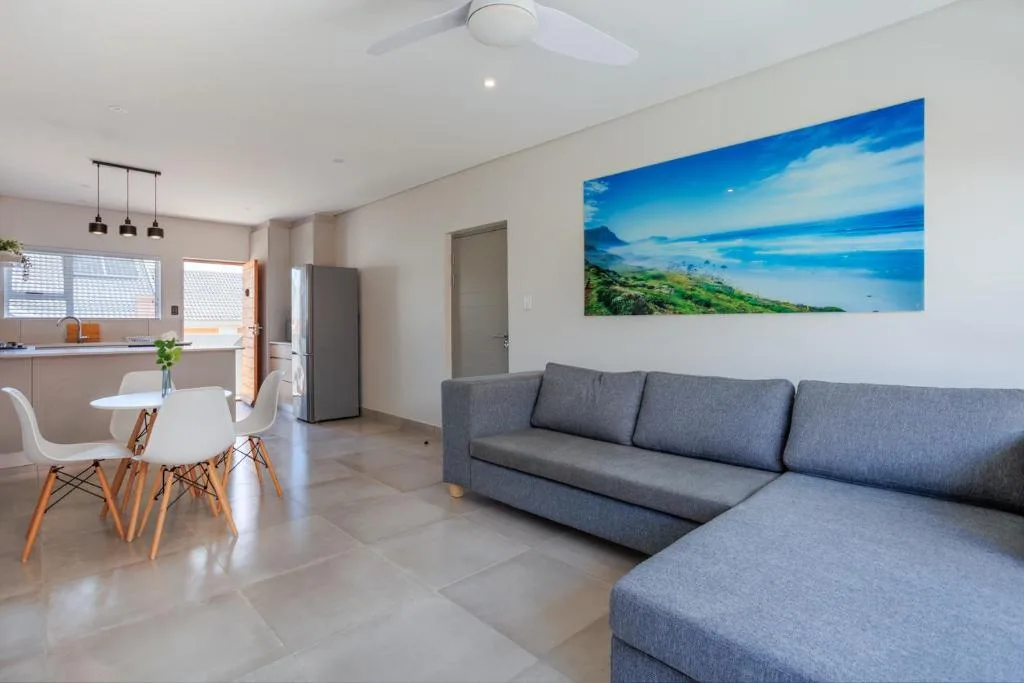 Modern lounge with gray sectional sofa and scenic landscape artwork