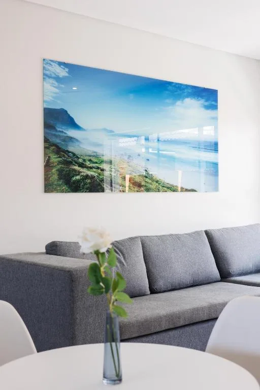 Modern lounge with gray sofa and coastal landscape artwork on wall