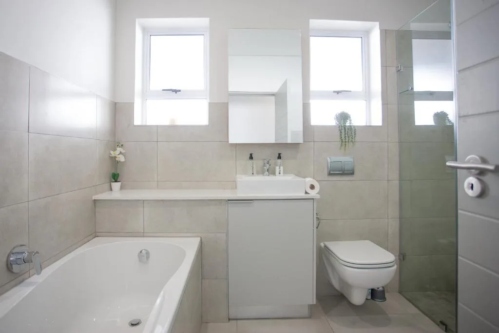 Modern bathroom with bathtub, vanity sink, toilet, and shower enclosure