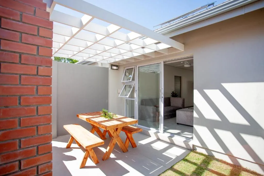 Covered patio with wooden picnic table and bench seating area