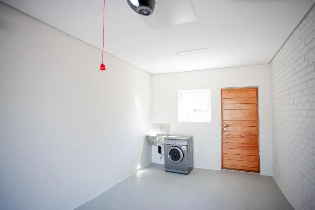 Modern laundry room with washing machine and wooden door